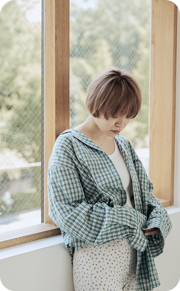 俯く窓際の女性